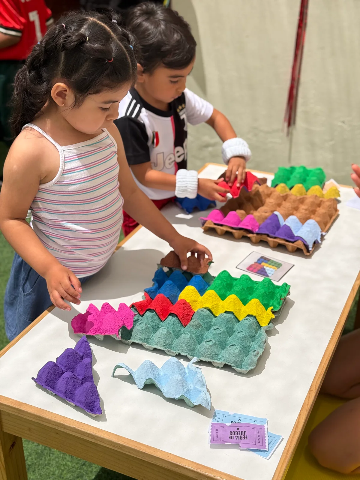 Niños creando y ordenando piezas de colores durante una actividad en Ohana
